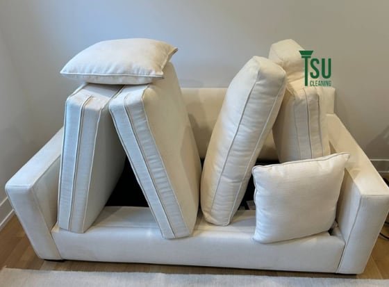 Light-colored sofa cushions set upright to dry after a fabric-matched clean by TSU Cleaning